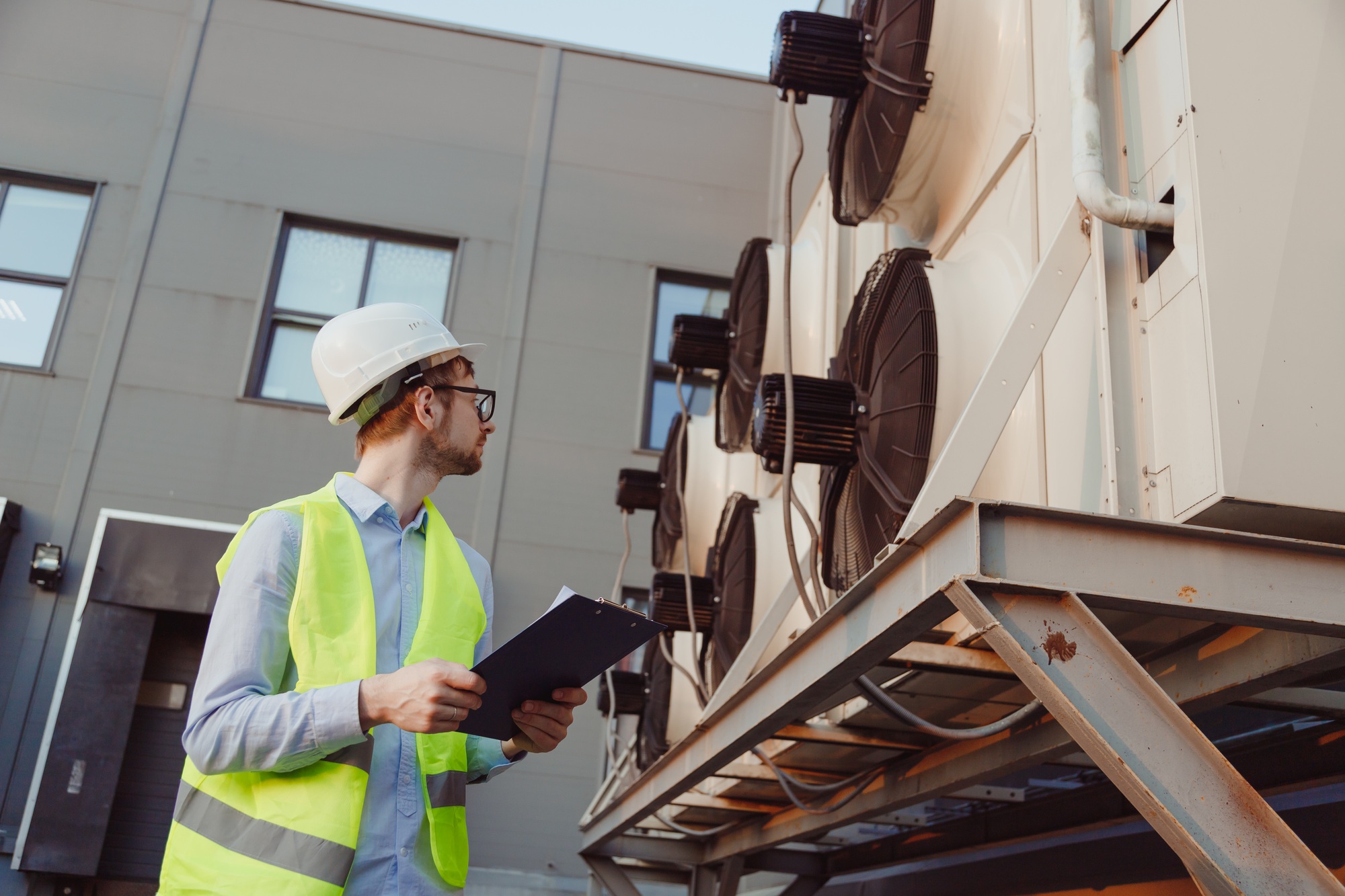 Service hvac engineer in uniform inspecting industrial refrigeration system